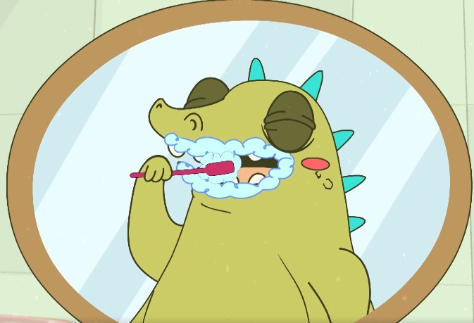 La imagen muestra un cocodrilo en caricatura frente al espejo cepillándose los dientes. Su boca se ve llena de espuma de la crema dental.
