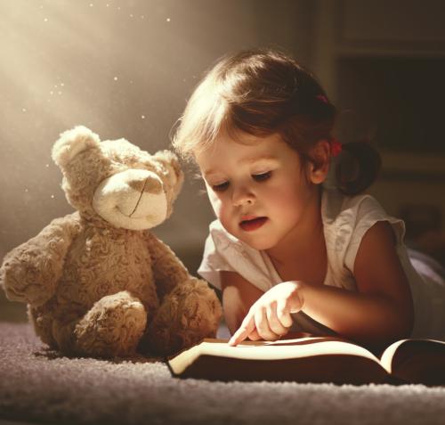 Niña leyendo a oso