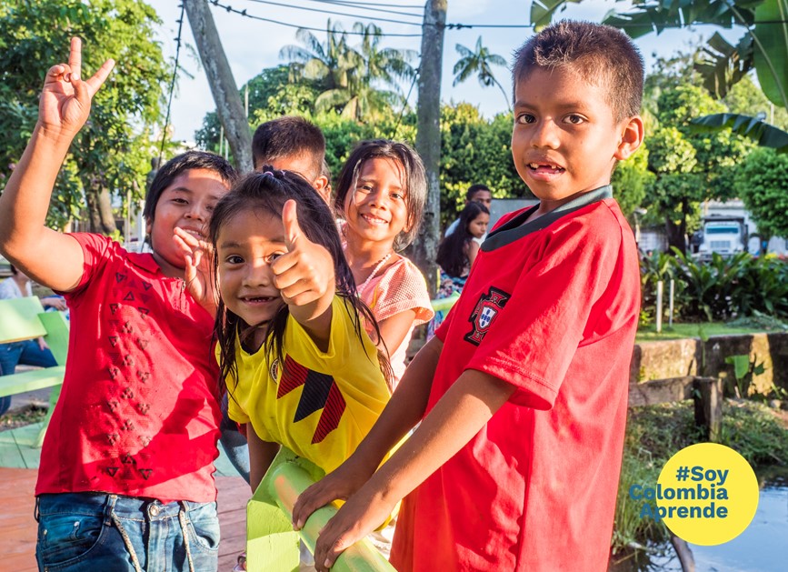 Foto de niños con camisas deportivas sonriendo a la camara