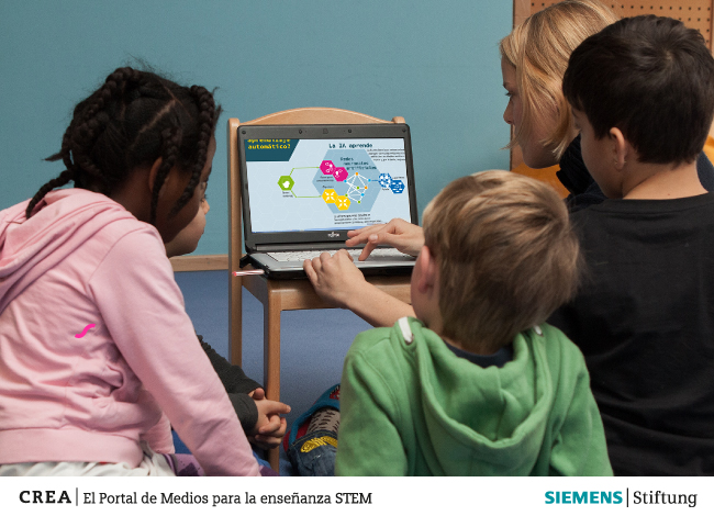 Una profesora con tres niños frente a un computador explorando el portal de medios CREA