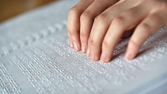foto de una mano sobre braille