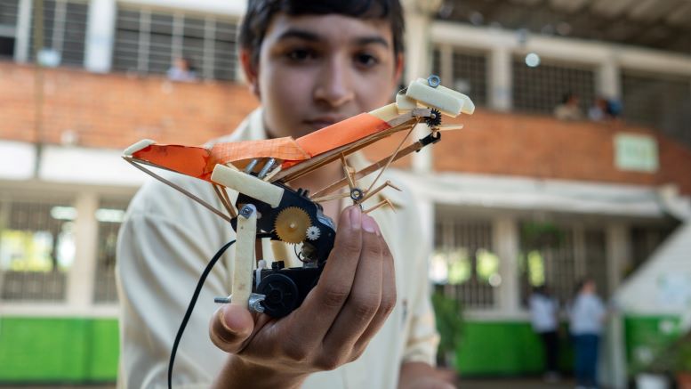 joven estudiante con robot en su mano