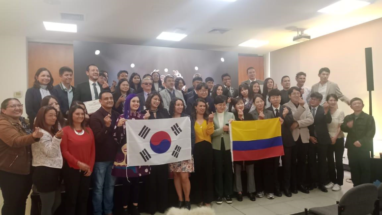Foto de muchos hombre y mujeres con bandera de Corea del Sur y Colombia sonriendo ante la cámara