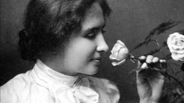 foto en blanco y negro de Hellen Keller quien tiene una rosa y la huele