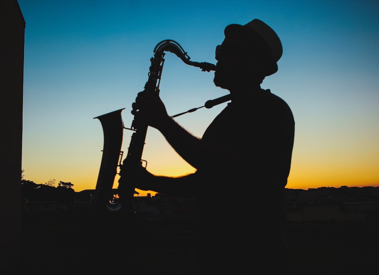 Silueta De Un Hombre Tocando El Saxofón Durante La Puesta De Sol