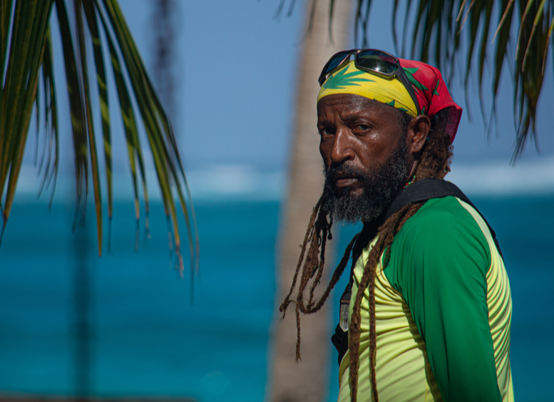 Fotografía de hombre negro raizal con rastas y al fondo el mar