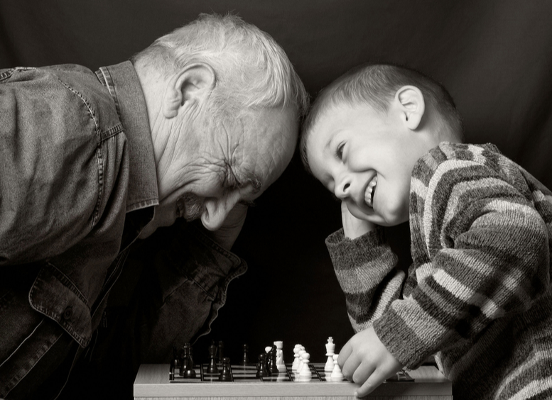 Foto en blanco y negro, de Abuelo con nieto jugando al ajedrez