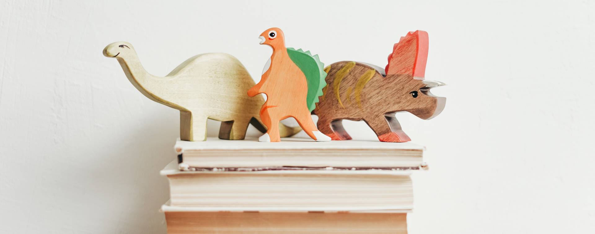 Foto de unos libros con unos dinosaurios de decoración encima