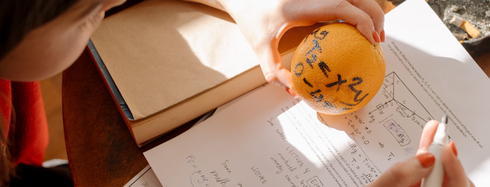 Niño realizando ecuaciones matemáticas con una naranja y un cuaderno