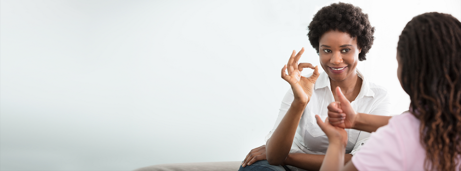 Foto de mujer y niña comunicándose en lenguaje de señas