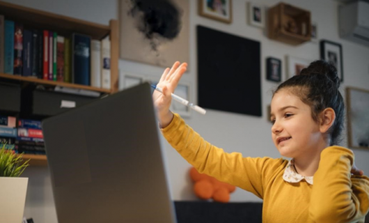 foto de una adolescente haciendo gestos de felicidad frente a un portátil
