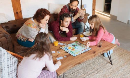 Foto de una familia en una sala compartiendo con juegos de mesa