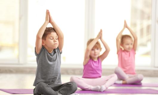 Niños en sesión de yoga y respiración, sentados en el piso