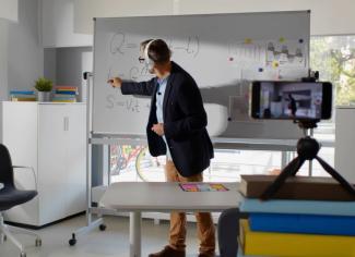 Docente en cámara grabando una clase frente al tablero