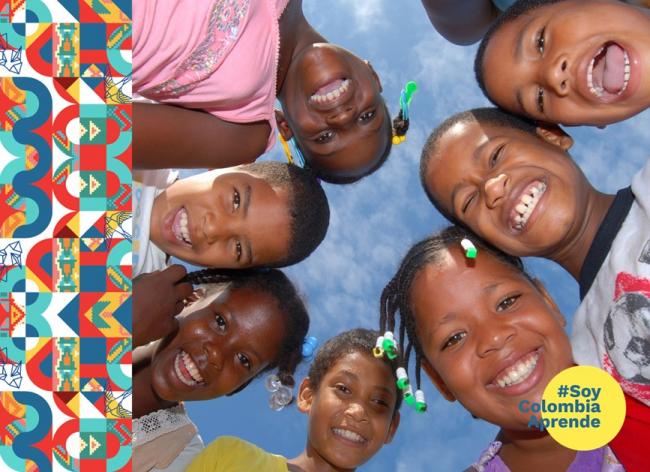 Foto de unos niños sonriendo frente a la camara