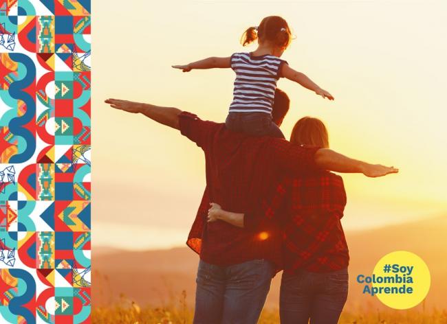 Familia simulando volar viendo el atardecer