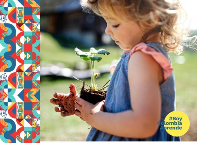 Foto de una niña con una planta en la mano