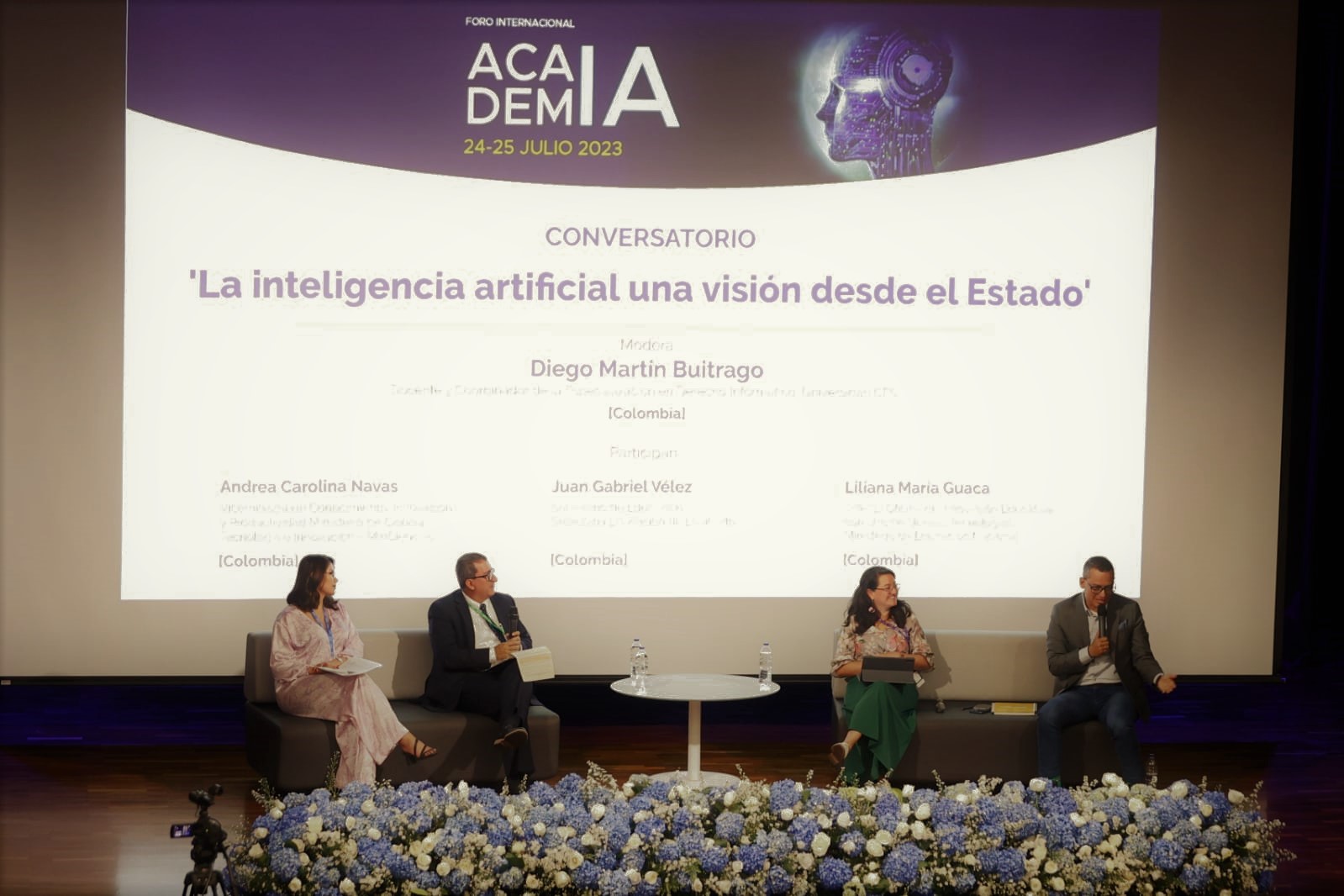 Foto de dos hombres y dos mujeres en tarima con letrero de fondo que dice 'La inteligencia artificial: una visión desde el Estado