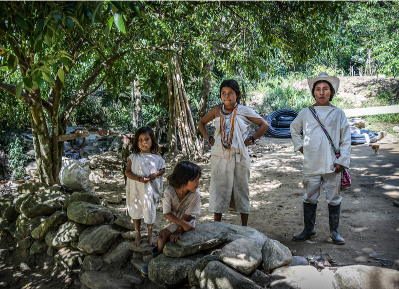 Pareja de indígenas kogi con sus dos niños, vestidos de blanco en la Sierra Nevada de Santa Marta, Colombia