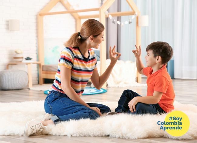 Foto mujer y niño comunicándose por medio del Lenguaje de Señas